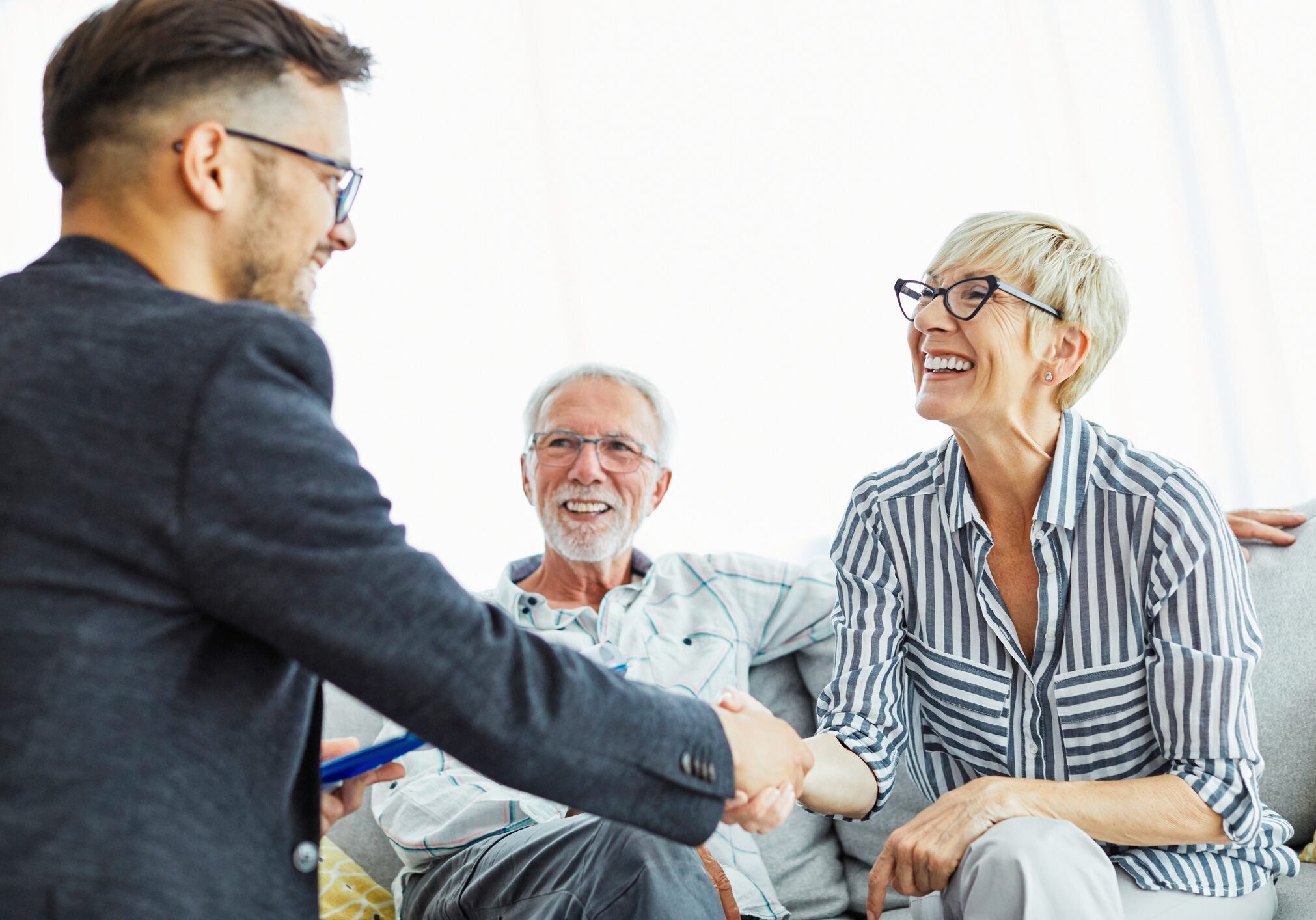 People smiling and shaking hands in meeting.