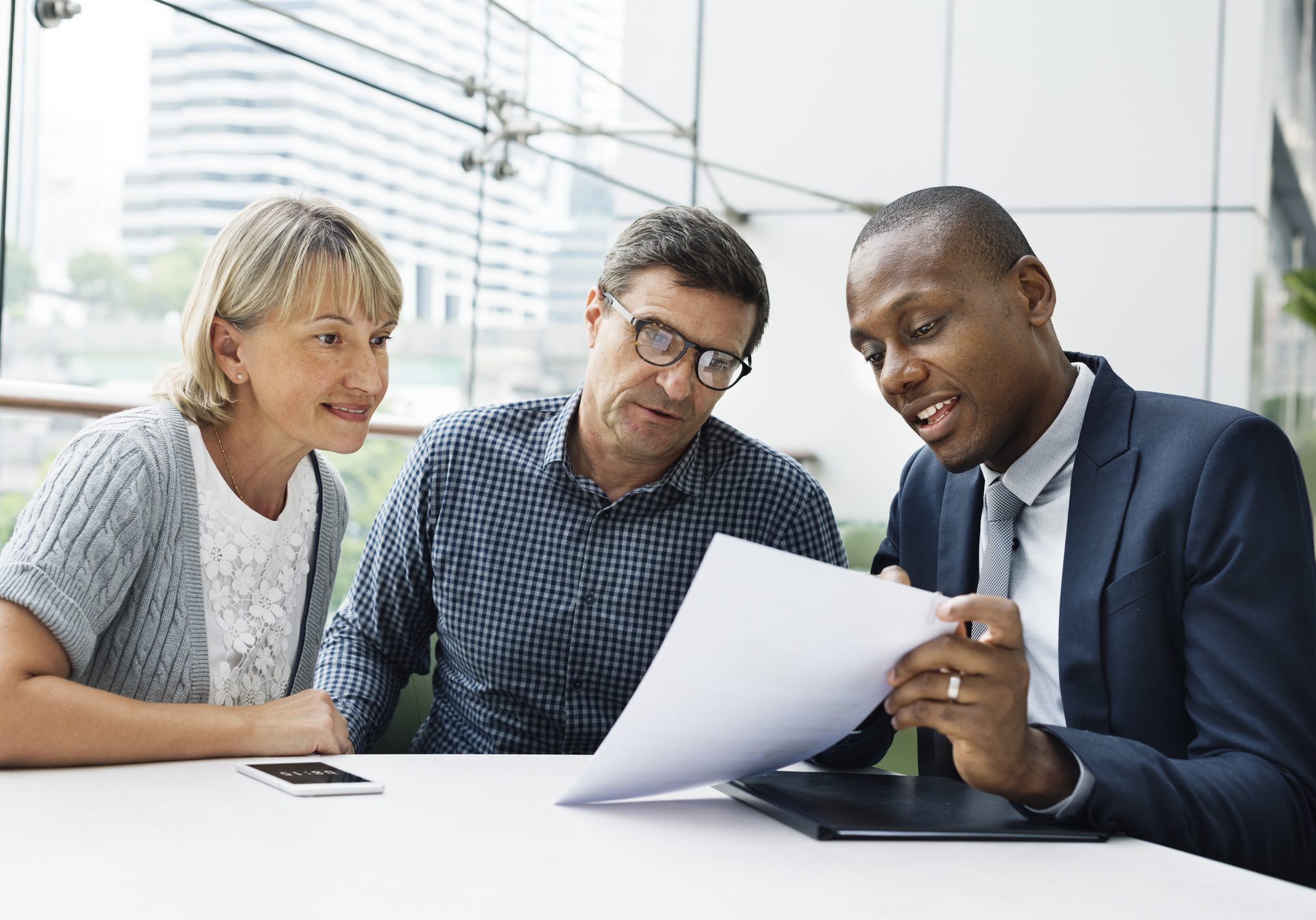 People discussing documents in an office setting.